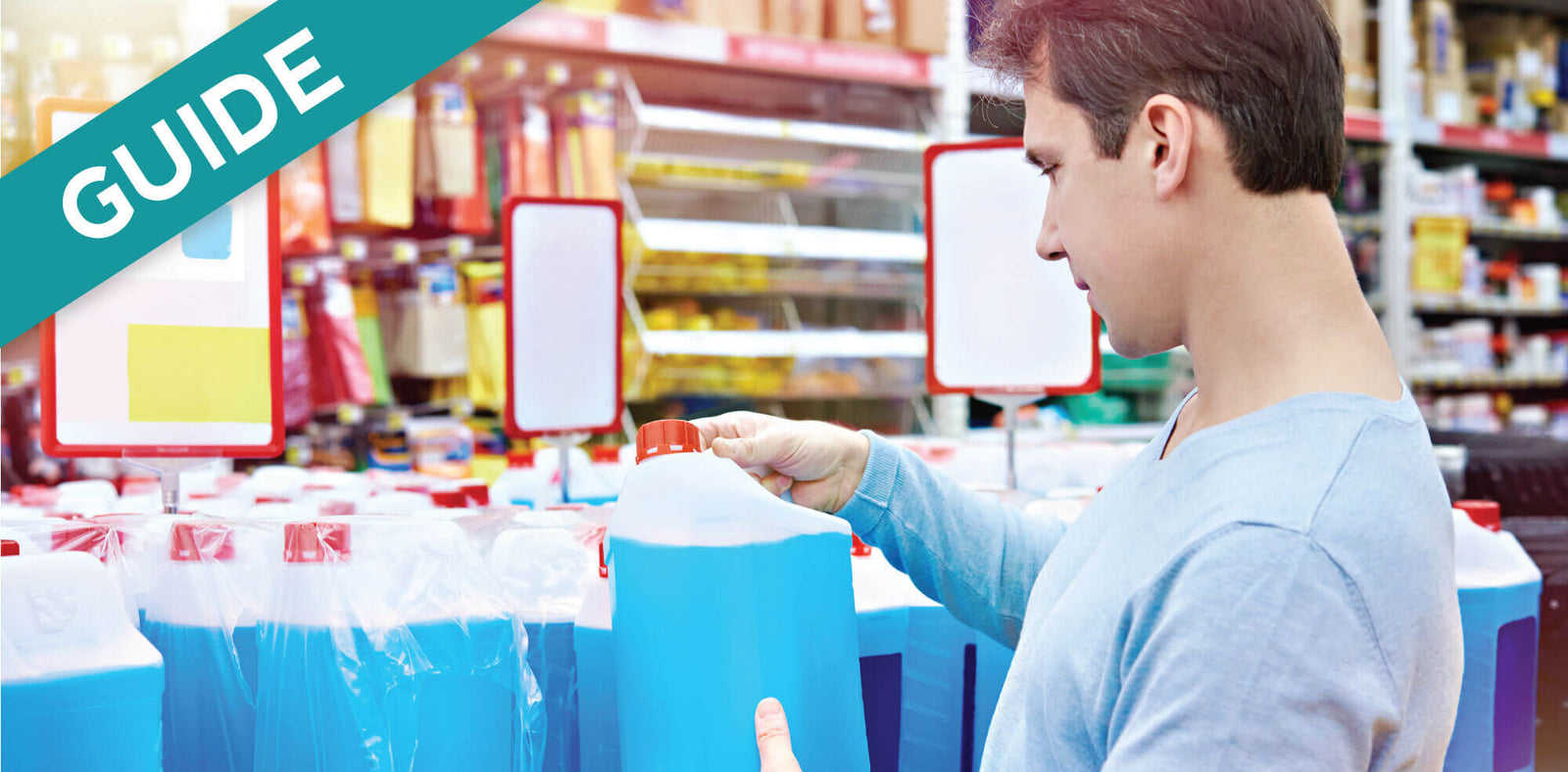 Man examining large blue antifreeze jug in store aisle.