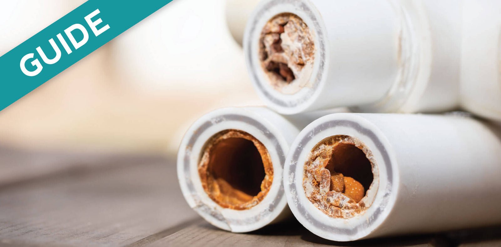 Clogged RV toilet line showing severe mineral buildup inside white plastic pipes.