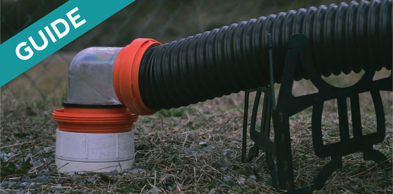 RV sewer hose adapter with clear elbow connected to a black corrugated hose for dumping holding tanks.