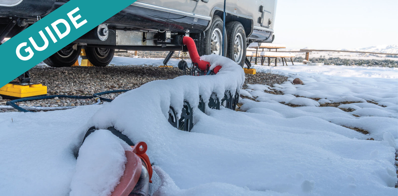 RV water hose covered in snow, illustrating how to keep RV holding tanks from freezing.