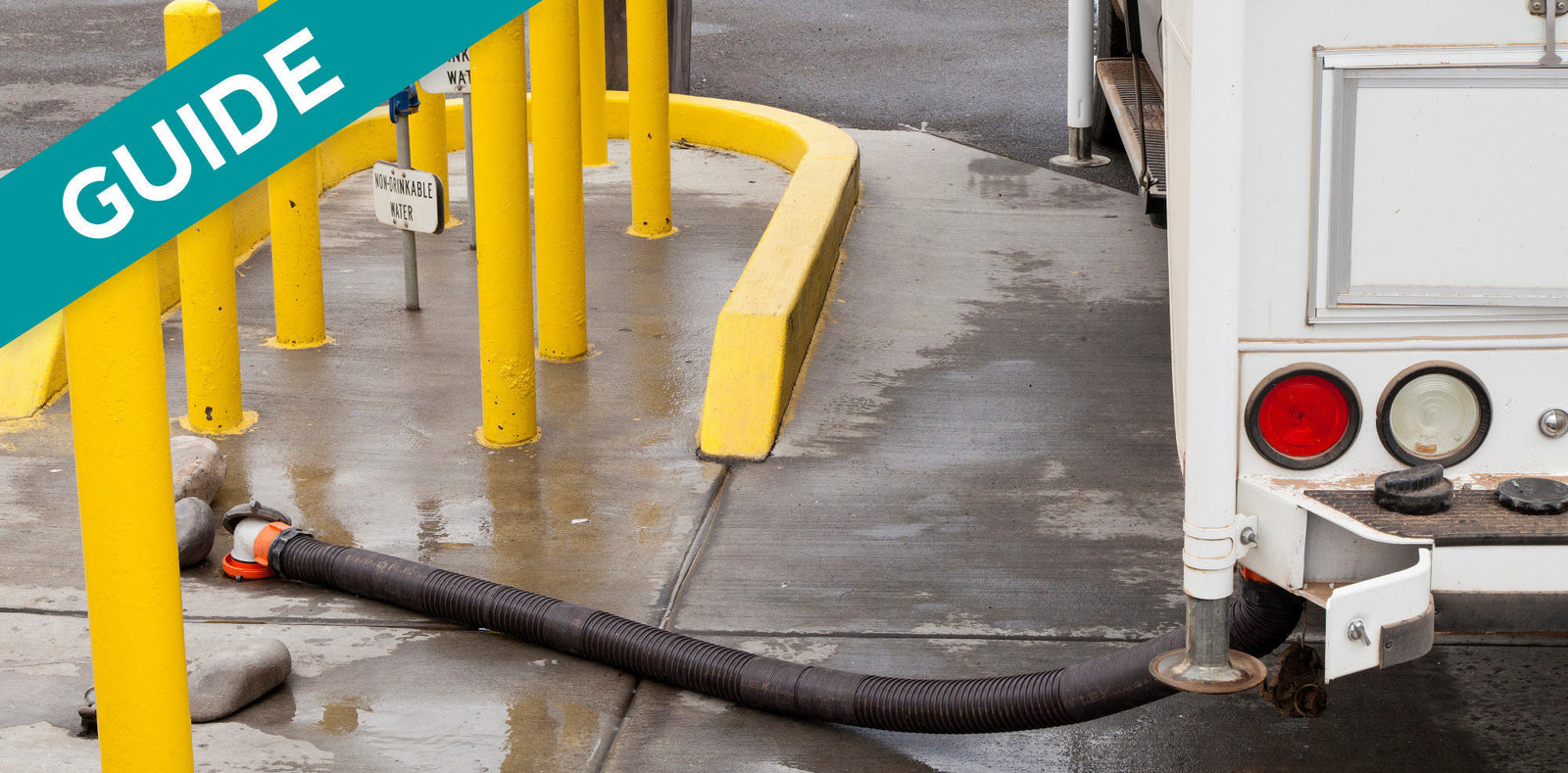 RV sewer hose connected to a dump station with a "Non-Potable Water" sign.