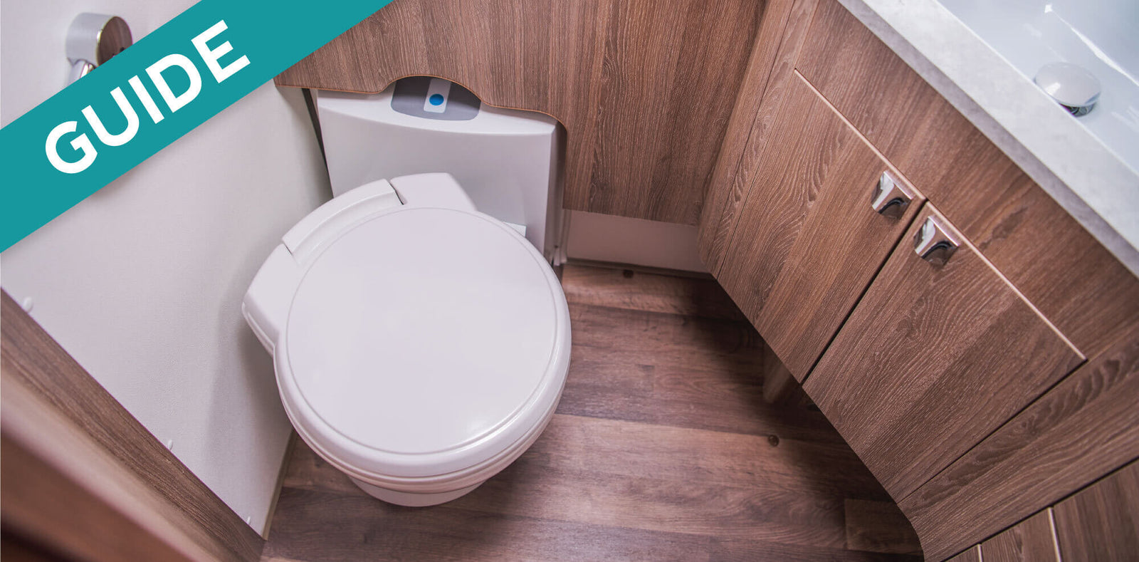 The Complete Guide - Treating Your RV Toilet layered over a journal and two pens