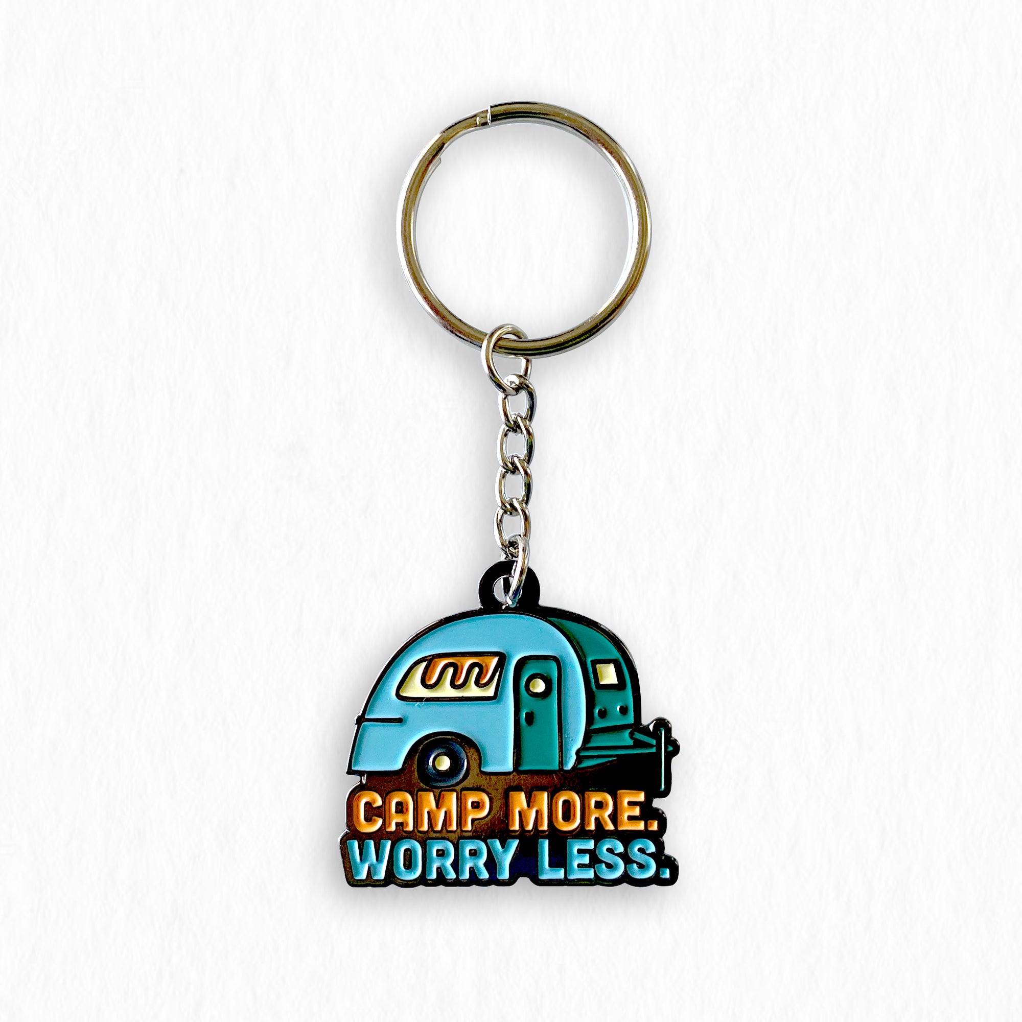 Camp More. Worry Less. Trailer keychain. Hanging on a white wall.