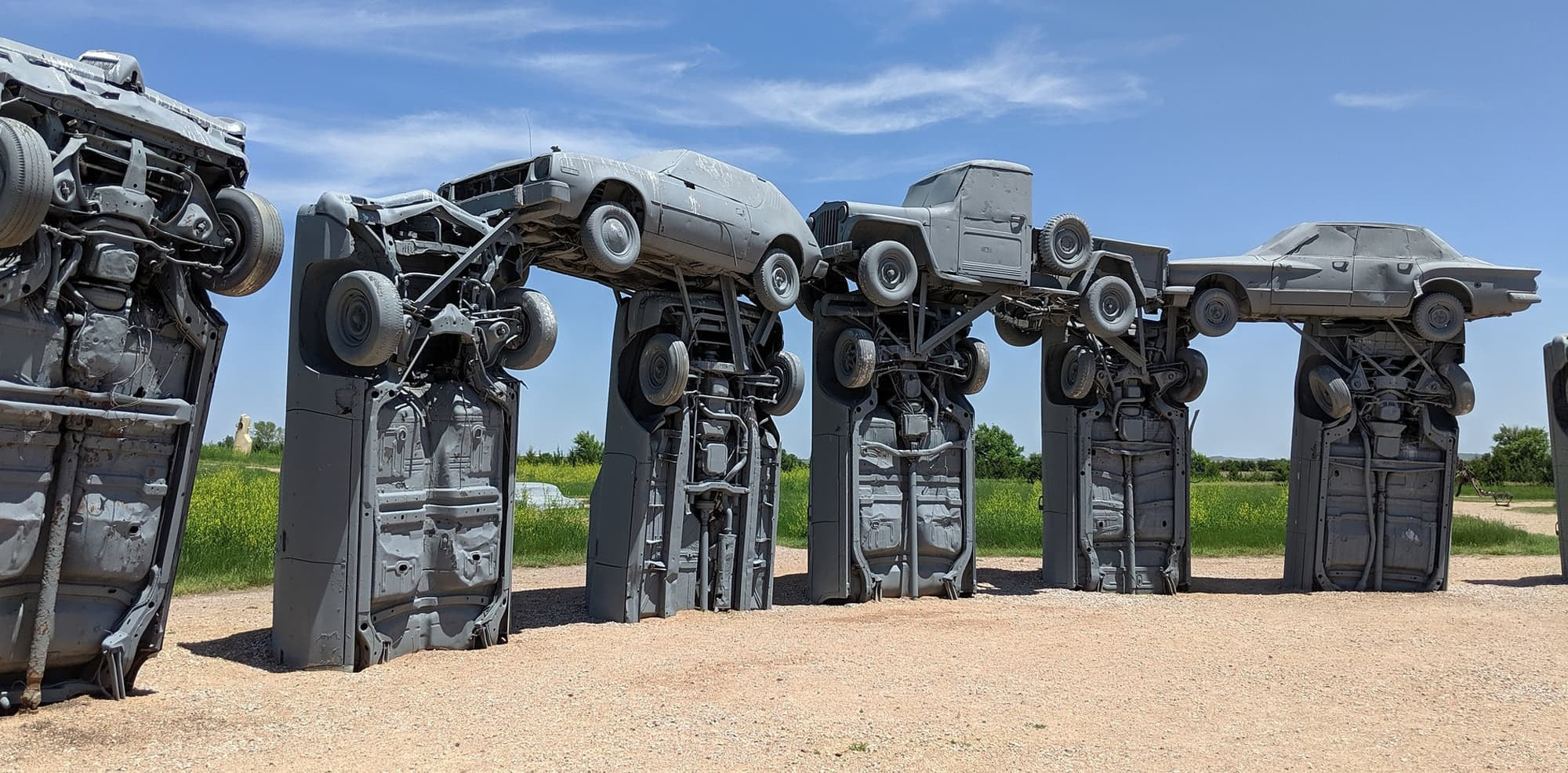 Carhenge found in Alliance, Nebraska a sight to behold gray painted cars piled on top of eachother.