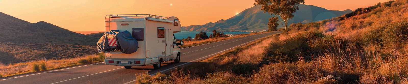 RV on the road at sunset